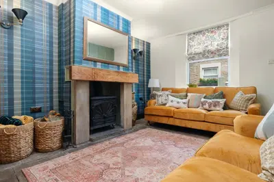 a living room with a couch and a fireplace at Elsie's Cottage in Ribchester
