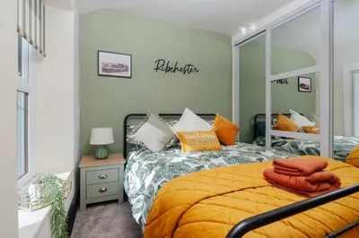 a bedroom with a large bed with orange sheets at Elsie's Cottage in Ribchester