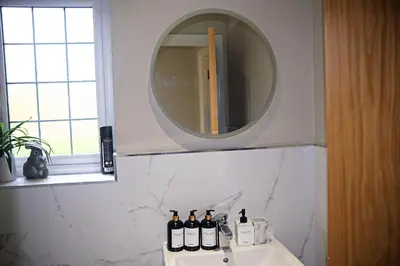 a bathroom with a mirror and a sink at Thirlmere in Upholland