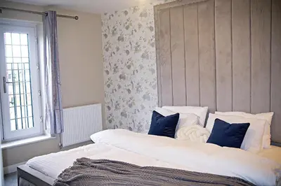 a bedroom with a large white bed with blue pillows at Thirlmere in Upholland