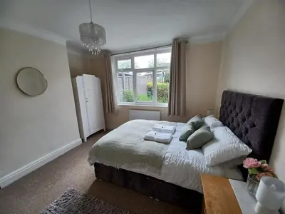 a bedroom with a large bed and a window at Heysham Seaside Hideaway in Heysham