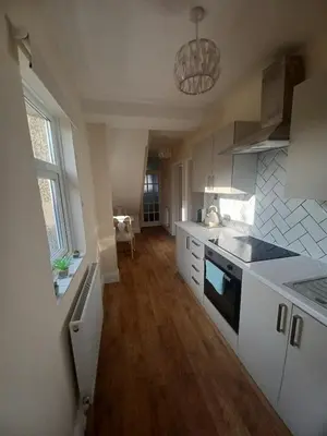 a kitchen with white cabinets and a counter top at Heysham Seaside Hideaway in Heysham
