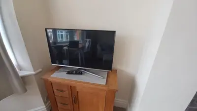 a flat screen tv sitting on top of a wooden cabinet at Heysham Seaside Hideaway in Heysham