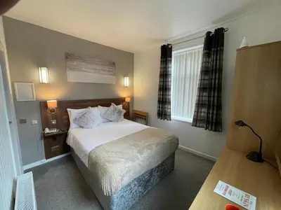 a hotel room with a bed and a window at Ruskin Hotel in Blackpool