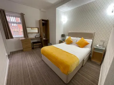 a bedroom with a bed with yellow sheets and pillows at Ruskin Hotel in Blackpool