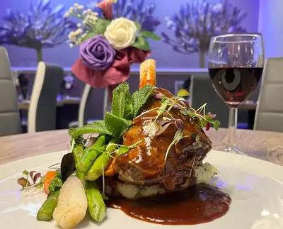 a plate of food on a table with a glass of wine at Ruskin Hotel in Blackpool