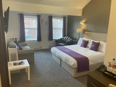 a hotel room with a large bed and a chair at Ruskin Hotel in Blackpool