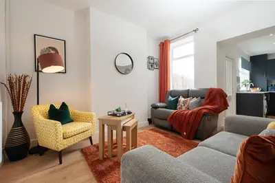 a living room with a couch and a chair at Entire 4 Bedroom house in Bootle Liverpool-Ideal for contractors, family and group-Free Parking & Free internet-Sleeps 7 in Litherland