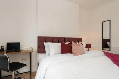 a bedroom with a bed with a mirror and a desk at Entire 4 Bedroom house in Bootle Liverpool-Ideal for contractors, family and group-Free Parking & Free internet-Sleeps 7 in Litherland
