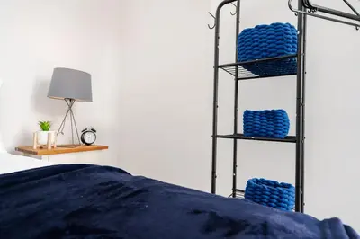 a bedroom with a bed and a black shelving unit at Entire 4 Bedroom house in Bootle Liverpool-Ideal for contractors, family and group-Free Parking & Free internet-Sleeps 7 in Litherland