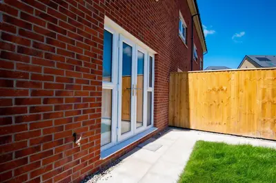 a window on the side of a brick building at Luxury 5BDR with City Access, Free Parking and Wi-Fi in Ince-in-Makerfield
