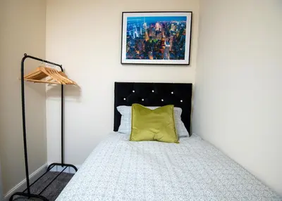 a bedroom with a bed with a yellow pillow at Luxury 5BDR with City Access, Free Parking and Wi-Fi in Ince-in-Makerfield