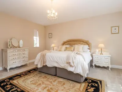 a bedroom with a bed and a chandelier at The Old Coach House in Preston