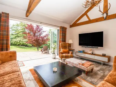 a living room with a couch and a tv at The Old Coach House in Preston