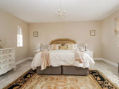 a bedroom with a bed and a chandelier at The Old Coach House in Preston