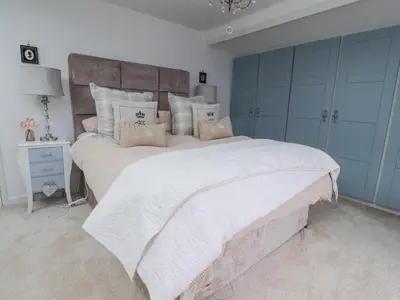 a bedroom with a large bed with a white bedspread at The Old Coach House in Preston