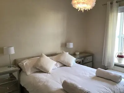 a bedroom with a bed with white sheets and pillows at Bridge Villas in Garstang