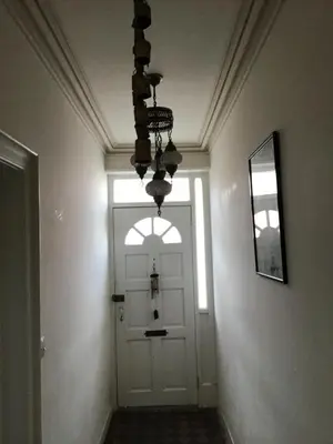 a hallway with a white door and a chandelier at Bridge Villas in Garstang