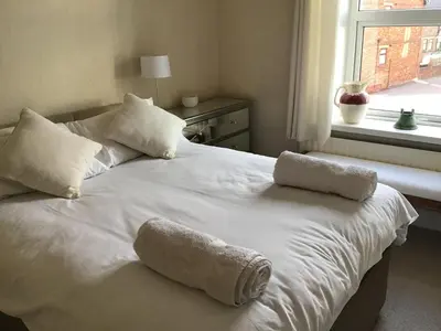 a white bed with two pillows and a window at Bridge Villas in Garstang