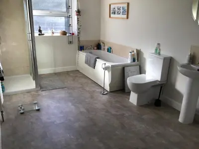 a bathroom with a tub and a toilet and a sink at Bridge Villas in Garstang