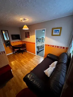 a living room with a leather couch and a dining room at Beachside Bliss In Blackpool 1 Bed Apartment in Blackpool