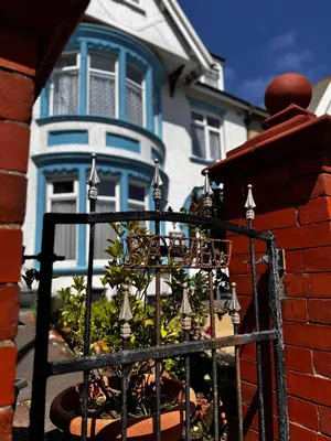 a blue and white house with a black fence at Beachside Bliss In Blackpool 1 Bed Apartment in Blackpool