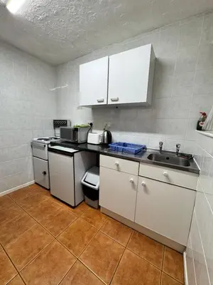 a kitchen with white cabinets and a sink at Beachside Bliss In Blackpool 1 Bed Apartment in Blackpool