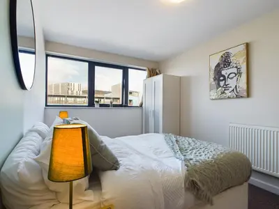 a bedroom with a bed and a lamp and a window at Group-Friendly City-Centre Flat Wifi, sleeps 4 in Liverpool