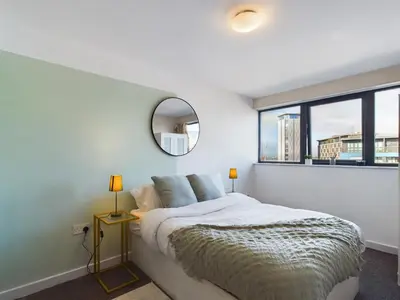 a bedroom with a bed with a mirror and a window at Group-Friendly City-Centre Flat Wifi, sleeps 4 in Liverpool