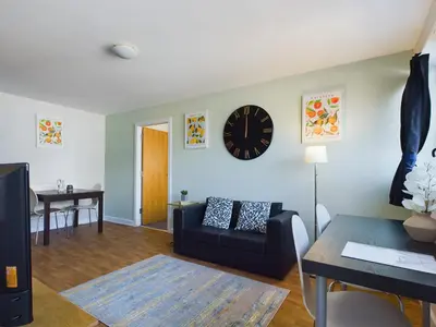 a living room with a couch and a clock on the wall at Group-Friendly City-Centre Flat Wifi, sleeps 4 in Liverpool