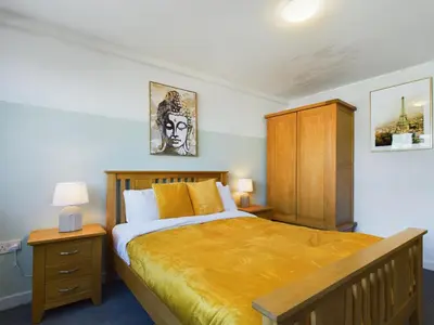 a bedroom with a large bed and a wooden cabinet at Group-Friendly City-Centre Flat Wifi, sleeps 4 in Liverpool