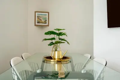 a dining room with a glass table with a potted plant at Modern London stay near Nothing Hill in Hoghton