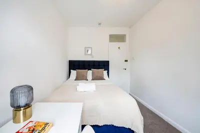 a small bedroom with a bed and a desk at Modern London stay near Nothing Hill in Hoghton