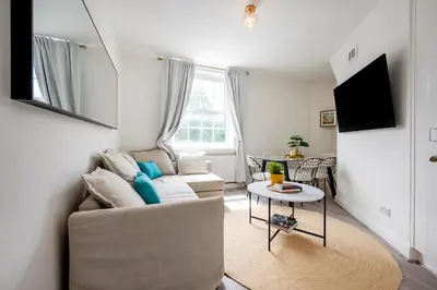 a living room with a couch and a table at Modern London stay near Nothing Hill in Hoghton