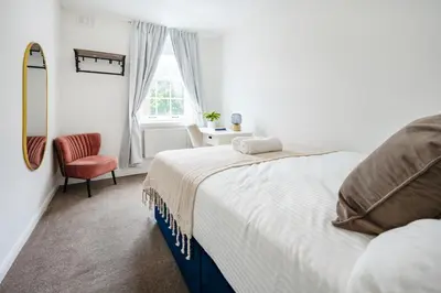 a bedroom with a bed and a chair and a window at Modern London stay near Nothing Hill in Hoghton