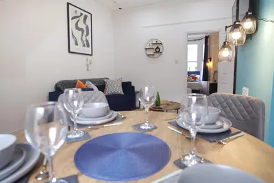 a dining room table with plates and wine glasses at Signature Coastal Suites - Two Chic & Stylish Apartments by Parydise Properties in Morecambe