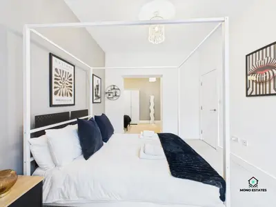a white bedroom with a large white bed with blue pillows at Knowledge Quarter - Near Uni and Lime St - 2 En Suite, 1 WC in Liverpool