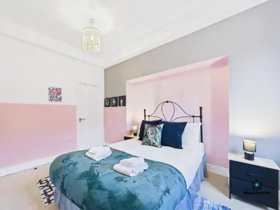 a bedroom with a large bed with towels on it at Knowledge Quarter - Near Uni and Lime St - 2 En Suite, 1 WC in Liverpool