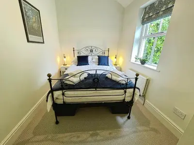 a bedroom with a bed with blue pillows and a window at 3 Chapel Square in Lancaster
