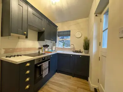 a kitchen with blue cabinets and a sink and a window at 3 Chapel Square in Lancaster