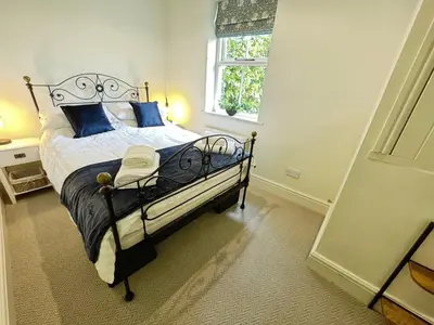 a bedroom with a bed with blue pillows and a window at 3 Chapel Square in Lancaster