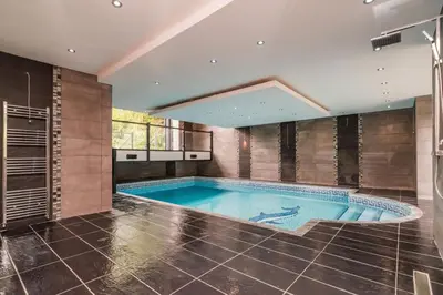 a large swimming pool in a room with a tile wall at The Luxury Country Home in Aughton