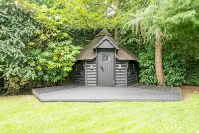 a dog house with a clock on it in a yard at The Luxury Country Home in Aughton