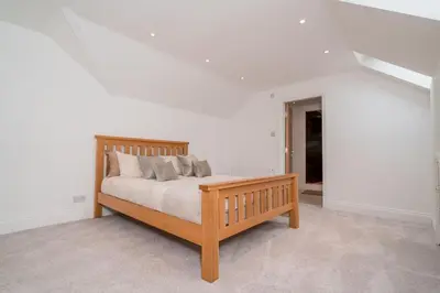a bedroom with a wooden bed with pillows at The Luxury Country Home in Aughton