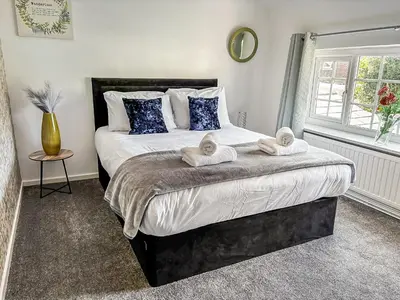 a bedroom with a large bed with towels on it at Yellow House Cottage in Southport