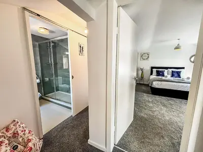 a room with a glass door leading to a bedroom at Yellow House Cottage in Southport