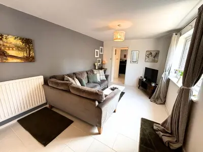 a living room with a couch and a television at Yellow House Cottage in Southport
