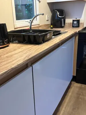 a kitchen counter with a sink and a stove at Lush Lake View in Millom