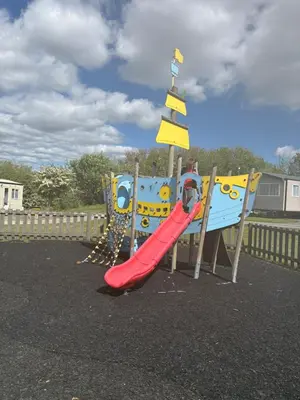 a childrens playground with a slide and a slideintend at Lush Lake View in Millom