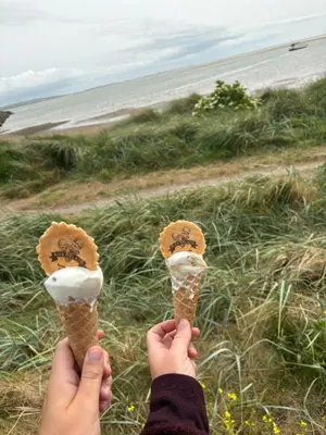 a person holding ice cream cones in front of the beach at Lush Lake View in Millom